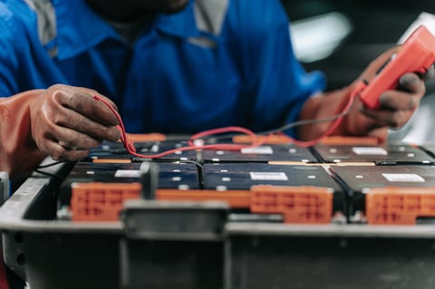 Technician diagnosing a car battery and charging system